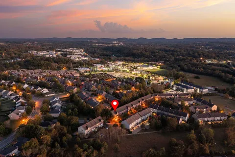 an aerial view of residential houses with outdoor space and trees