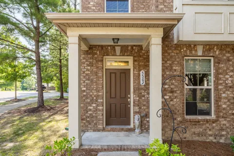 a front view of a house with a tree
