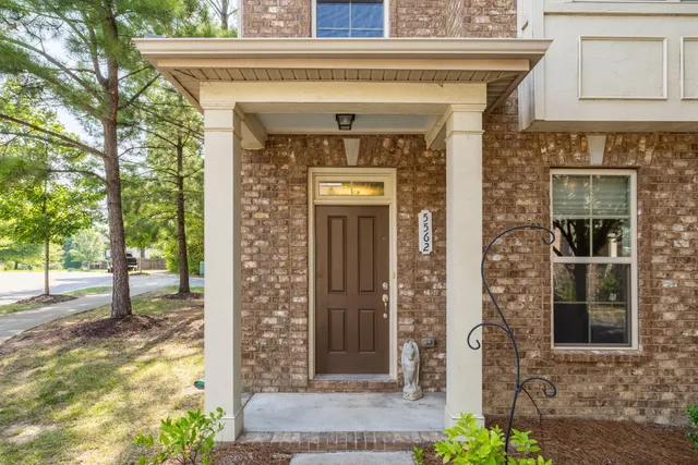 a front view of a house with a tree
