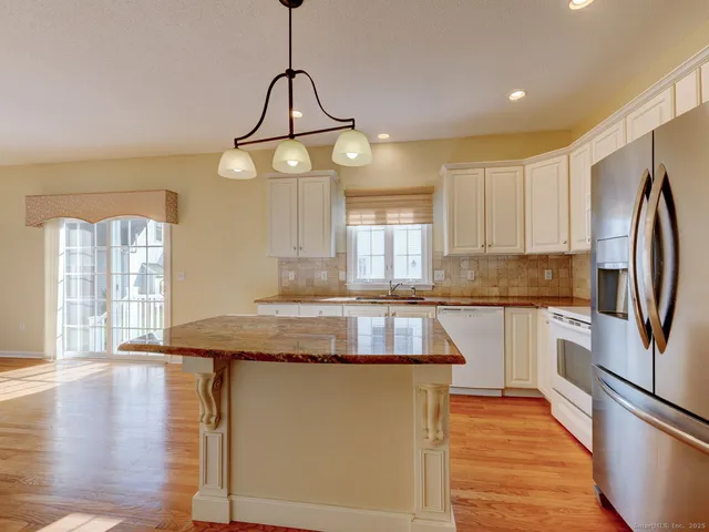 a kitchen with stainless steel appliances granite countertop a sink and dishwasher with white cabinets