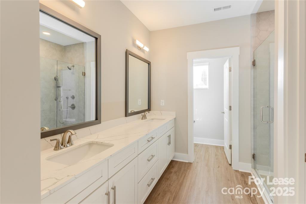 3110 Doe River Way, Unit WHITBY Matthews, NC 28105 - Photo 46 of 48 a spacious bathroom with a double vanity sink and mirror
