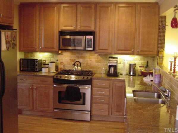 1101 Bancroft Street Raleigh, NC 27612 - Photo 4 of 10 a kitchen with stainless steel appliances granite countertop a stove a sink and a microwave