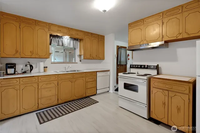 a kitchen with granite countertop a stove sink and cabinets