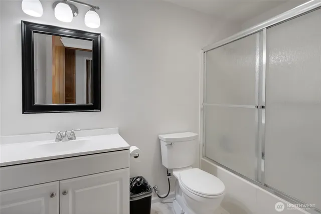 a bathroom with a toilet sink vanity and mirror