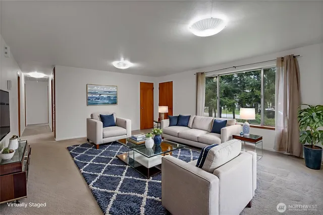 a living room with furniture a large window and a flat screen tv