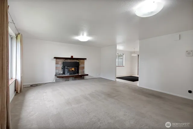 an empty room with fireplace and windows