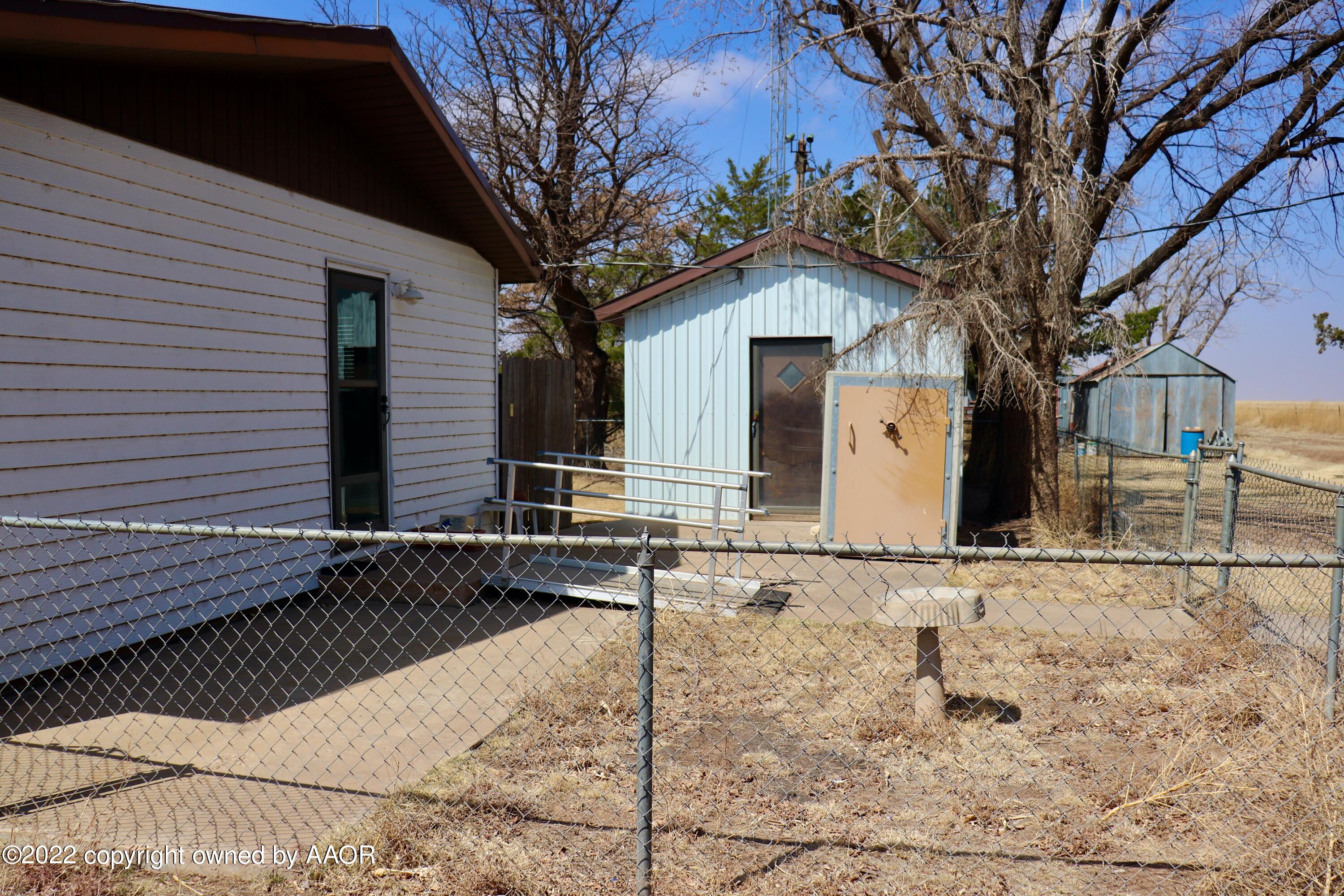 9540 Westline Road Wildorado, TX 79098 - Photo 9 of 61 a view of a white house with a large tree