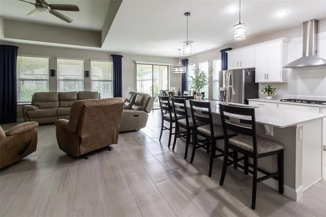 a kitchen with stainless steel appliances kitchen island granite countertop a table and chairs in it