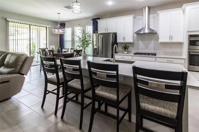 a kitchen with stainless steel appliances a stove a table and chairs