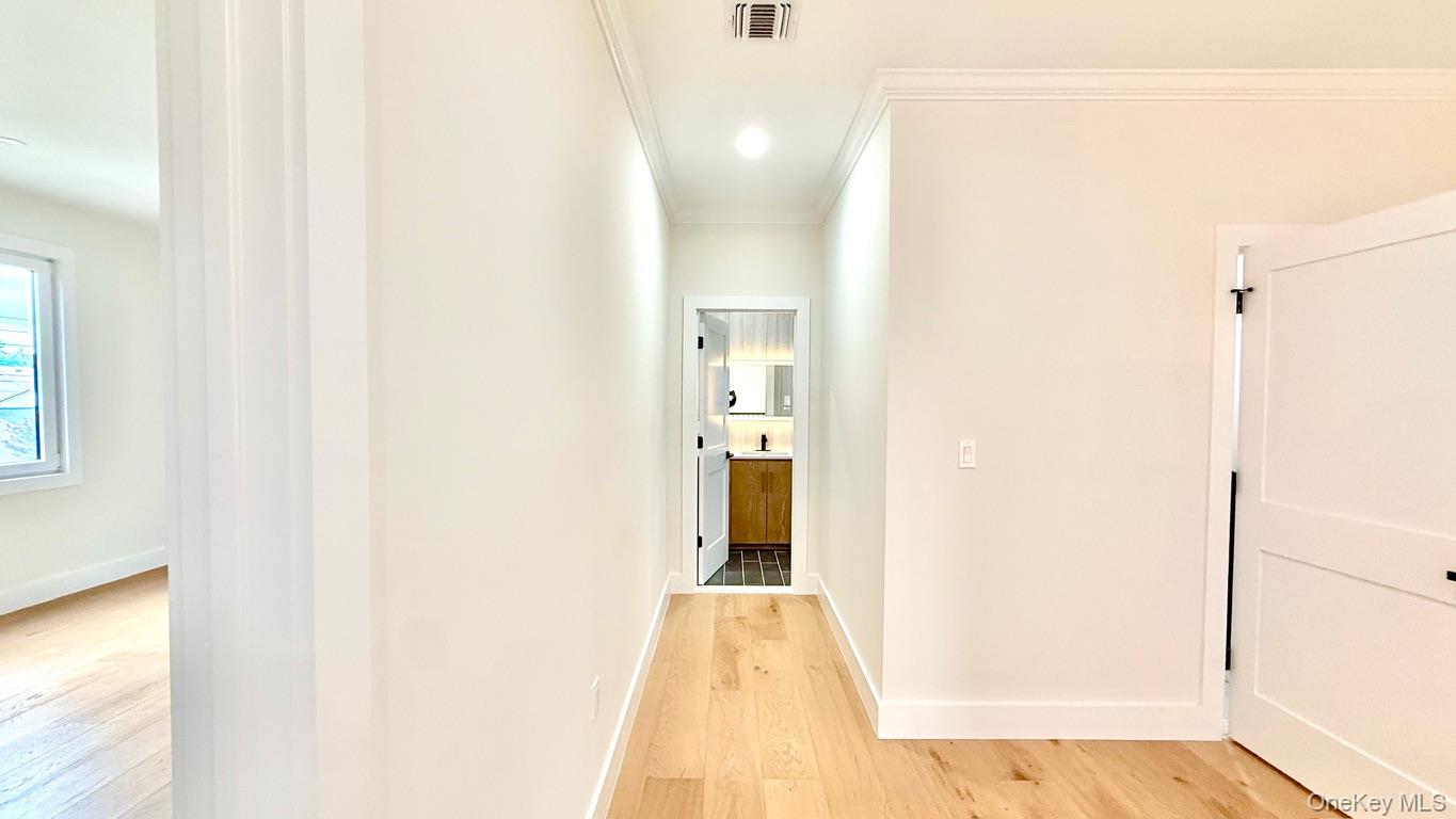 60 Periwinkle Road Levittown, NY 11756 - Photo 17 of 33 a view of a hallway with wooden floor and a bathroom