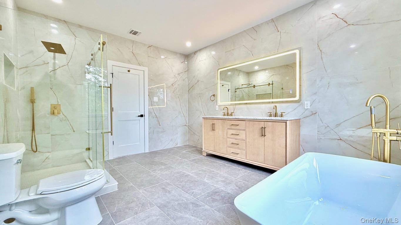 60 Periwinkle Road Levittown, NY 11756 - Photo 23 of 33 a spacious bathroom with a bathtub sink mirror and toilet