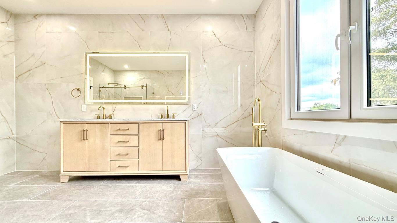 60 Periwinkle Road Levittown, NY 11756 - Photo 24 of 33 a bathroom with a tub a sink and a large mirror