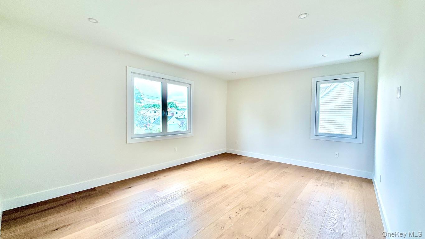 60 Periwinkle Road Levittown, NY 11756 - Photo 25 of 33 an empty room with wooden floor and windows