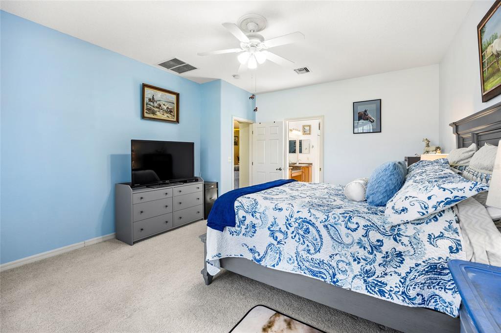 15092 Southwest 14th Avenue Road Ocala, FL 34473 - Photo 14 of 40 a bedroom with a bed and a flat screen tv