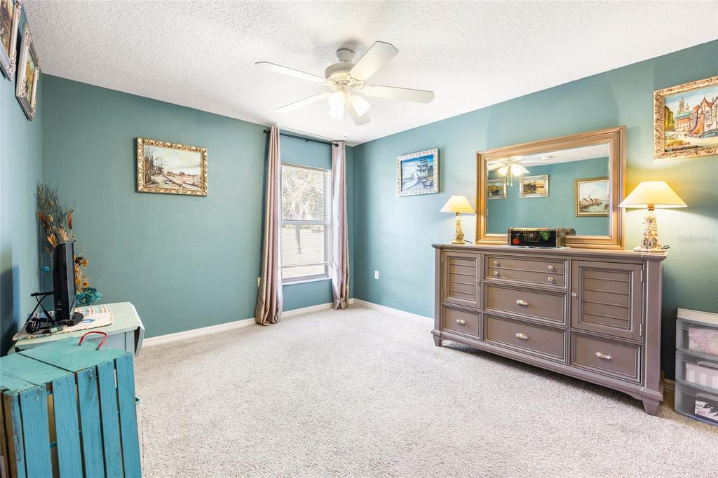 15092 Southwest 14th Avenue Road Ocala, FL 34473 - Photo 18 of 40 a bedroom with a bed and a chandelier