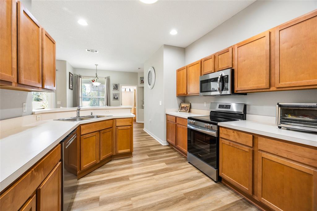 15092 Southwest 14th Avenue Road Ocala, FL 34473 - Photo 5 of 40 a large kitchen with stainless steel appliances granite countertop a stove a sink dishwasher and a microwave oven with white cabinets