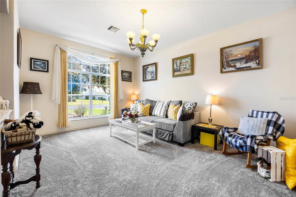 15092 Southwest 14th Avenue Road Ocala, FL 34473 - Photo 8 of 40 a living room with furniture a chandelier and a window