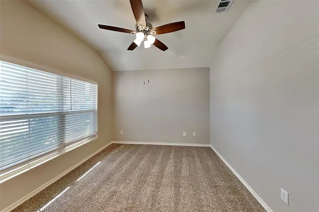 an empty room with a window and a fan