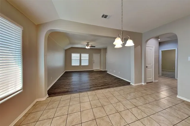 a view of a hallway with windows and chandelier
