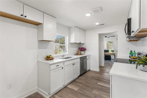 a kitchen with a sink cabinets and wooden floor