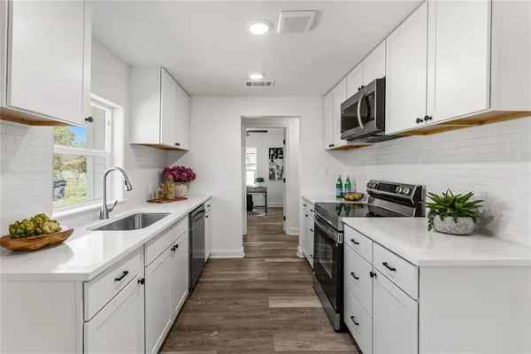 a kitchen with kitchen island white cabinets and white appliances