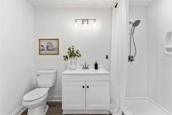 a bathroom with a shower sink vanity and toilet