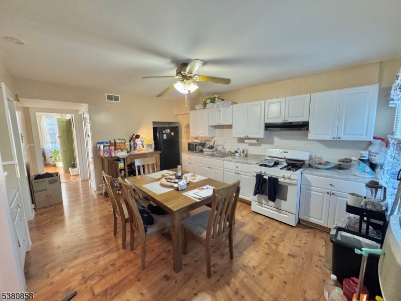 206 North 6th Street Prospect Park, NJ 07508 - Photo 13 of 18 a view of kitchen with cabinets stainless steel appliances and a dining table