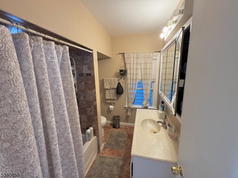206 North 6th Street Prospect Park, NJ 07508 - Photo 15 of 18 a bathroom with a sink a mirror and shower curtain