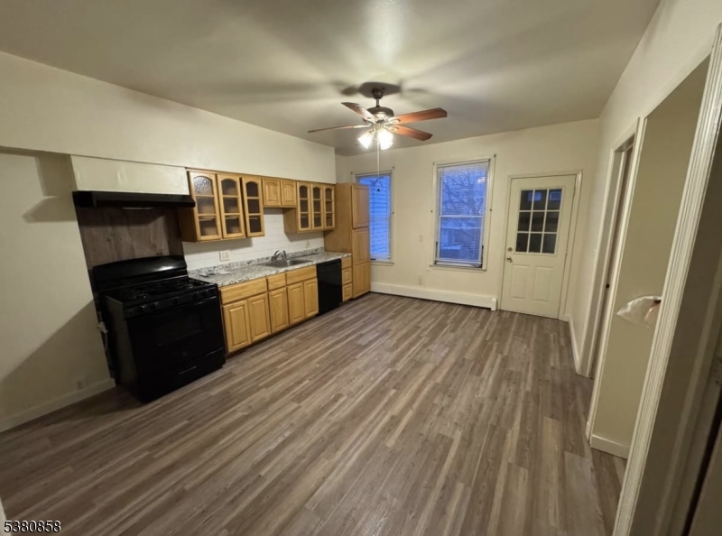 206 North 6th Street Prospect Park, NJ 07508 - Photo 10 of 18 a kitchen with granite countertop a stove top oven a sink dishwasher and a refrigerator with wooden floor