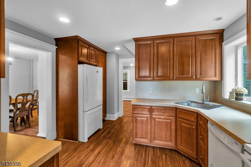 105 Somerville Road Bedminster, NJ 07921 - Photo 11 of 36 a kitchen with stainless steel appliances granite countertop a refrigerator a sink and wooden cabinets with wooden floor