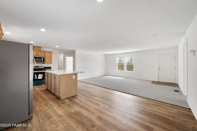 a large kitchen with stainless steel appliances a stove a sink a microwave and refrigerator