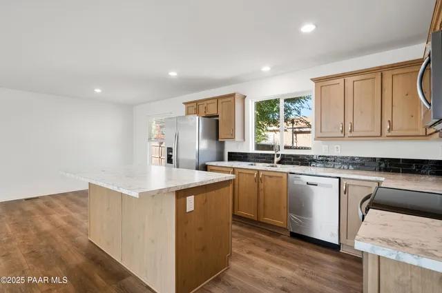 a room with a sink a counter top space and wooden floor