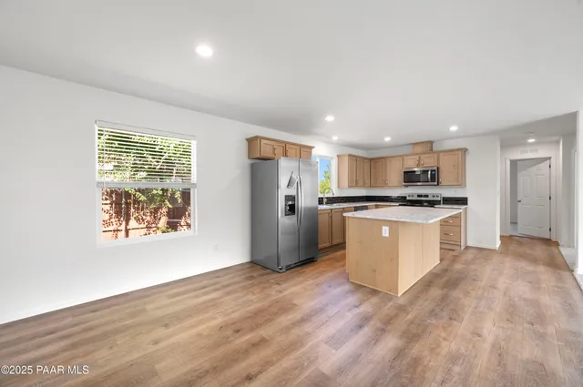 a kitchen with stainless steel appliances kitchen island wooden cabinets and granite counter tops