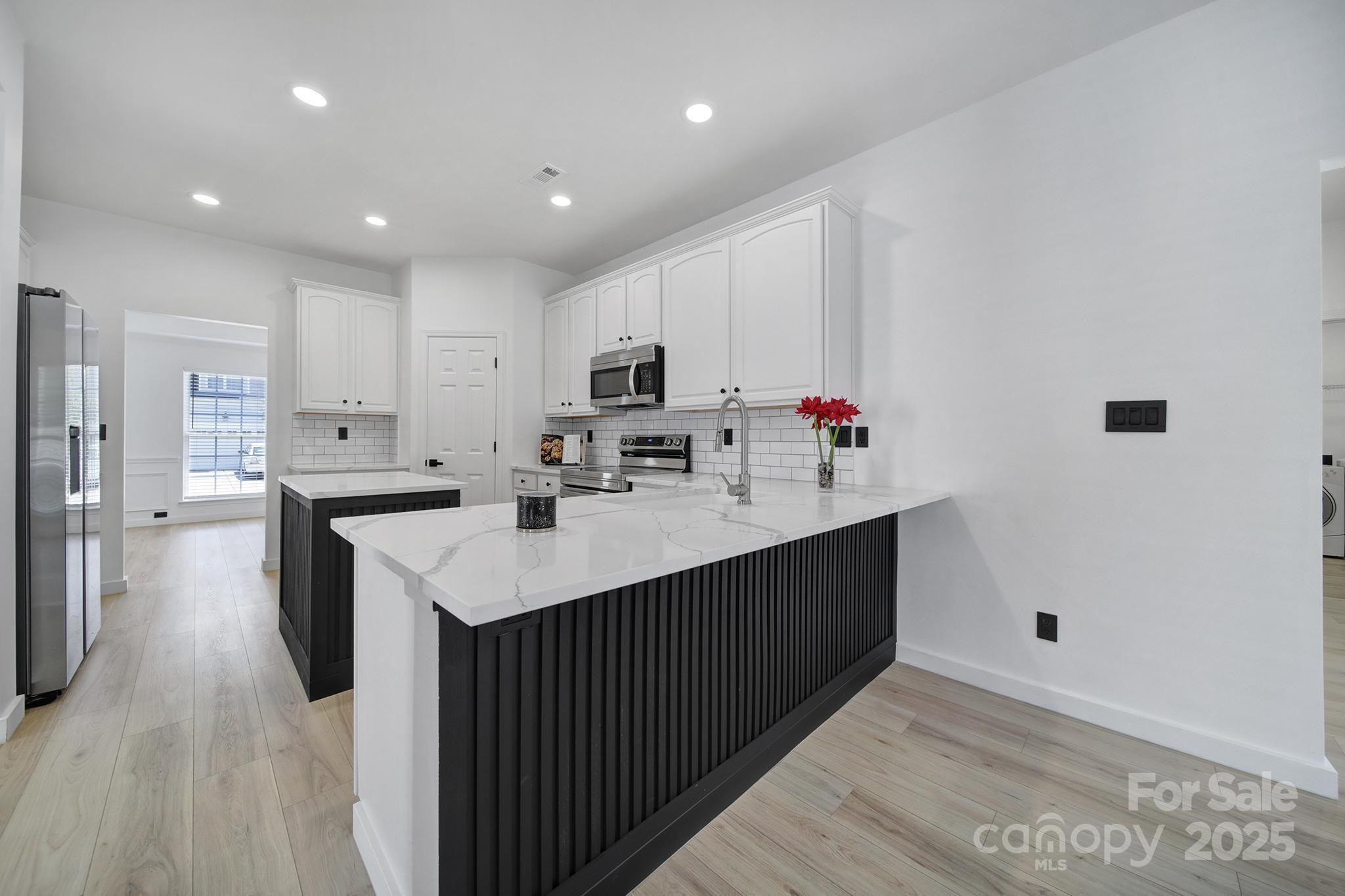 13425 Meadowmere Road Huntersville, NC 28078 - Photo 13 of 41 a kitchen with kitchen island a sink appliances and cabinets