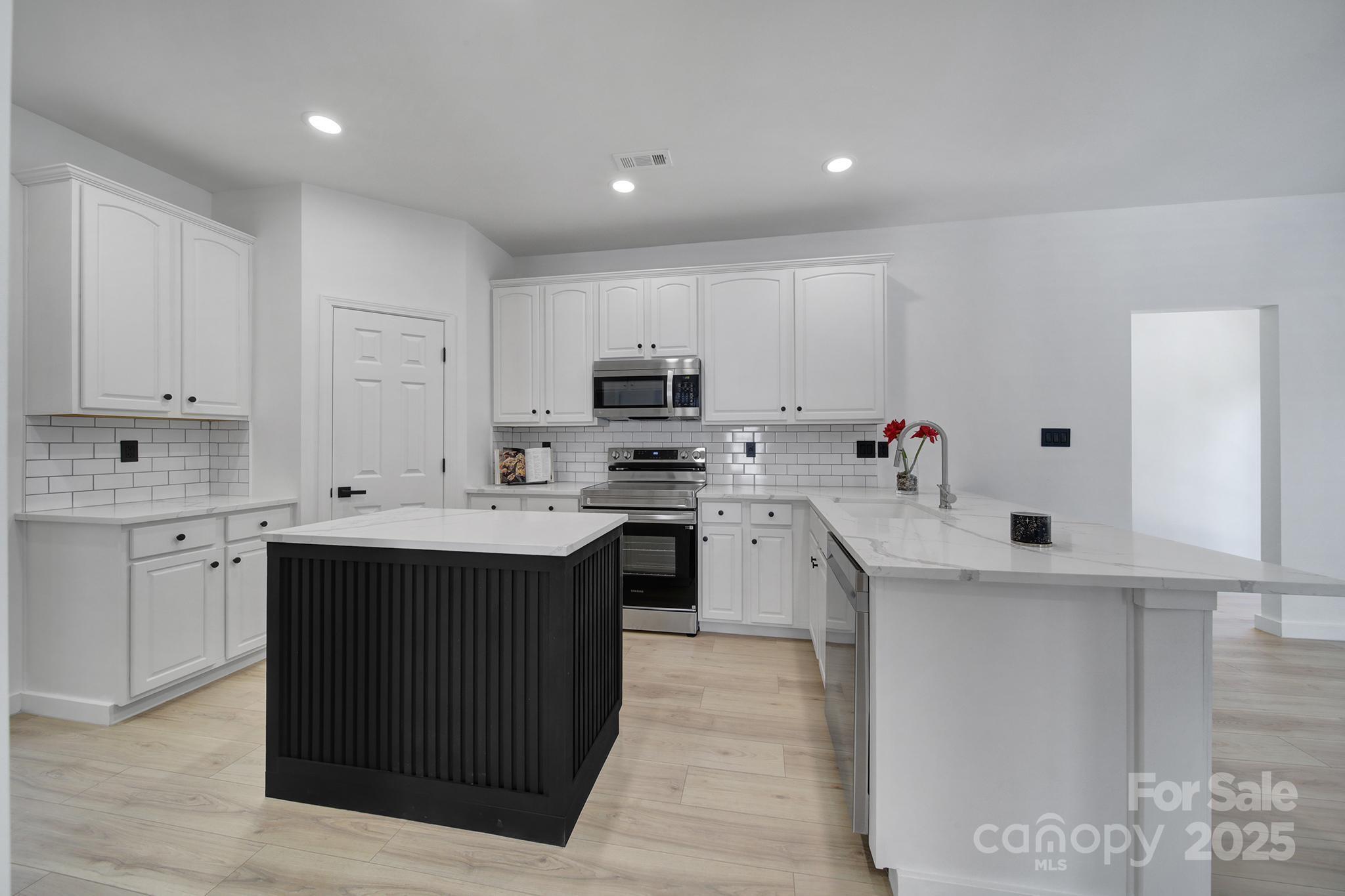 13425 Meadowmere Road Huntersville, NC 28078 - Photo 14 of 41 a kitchen with a sink stove top oven and cabinets