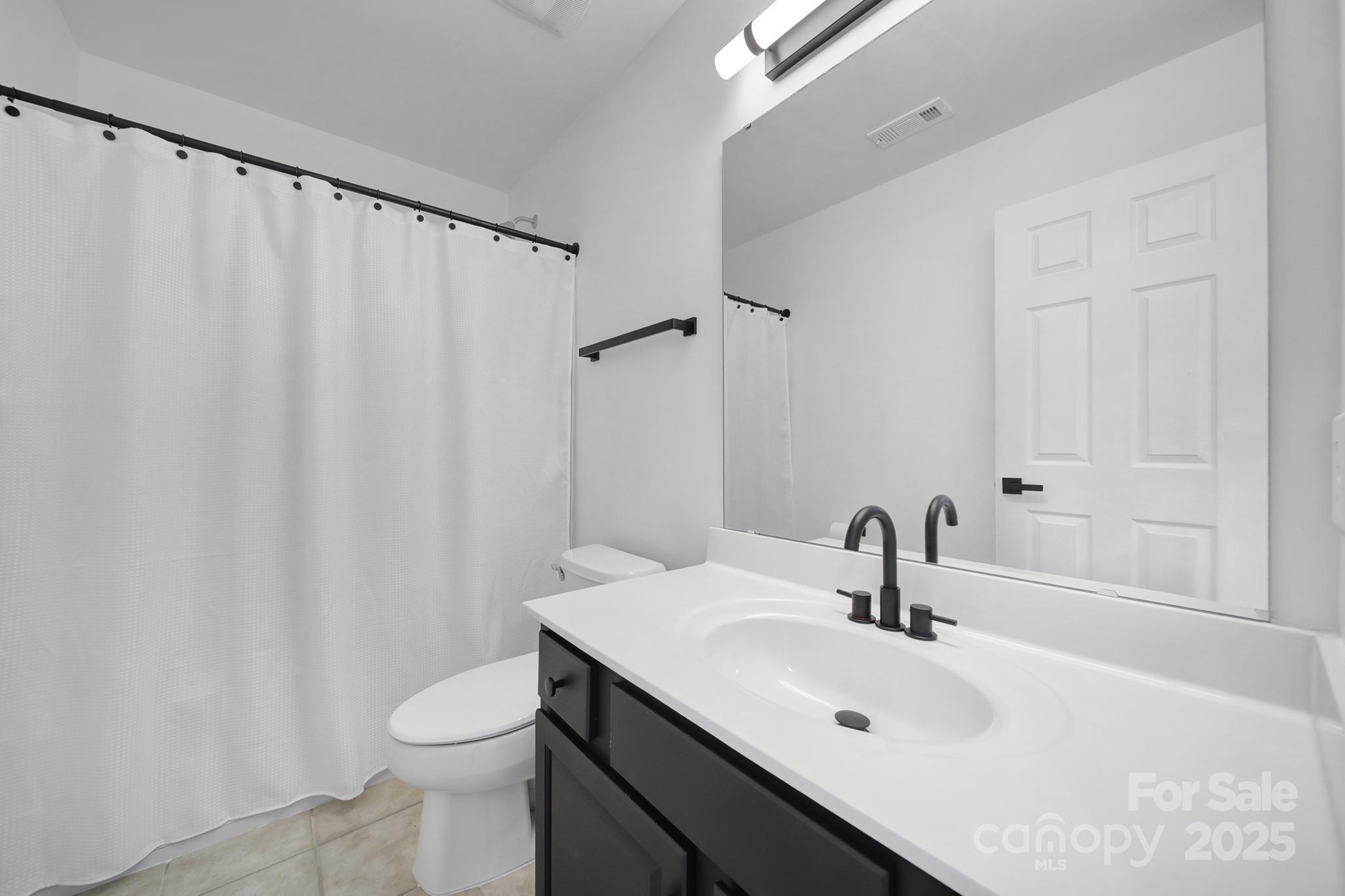 13425 Meadowmere Road Huntersville, NC 28078 - Photo 26 of 41 a bathroom with a sink a toilet and shower curtain