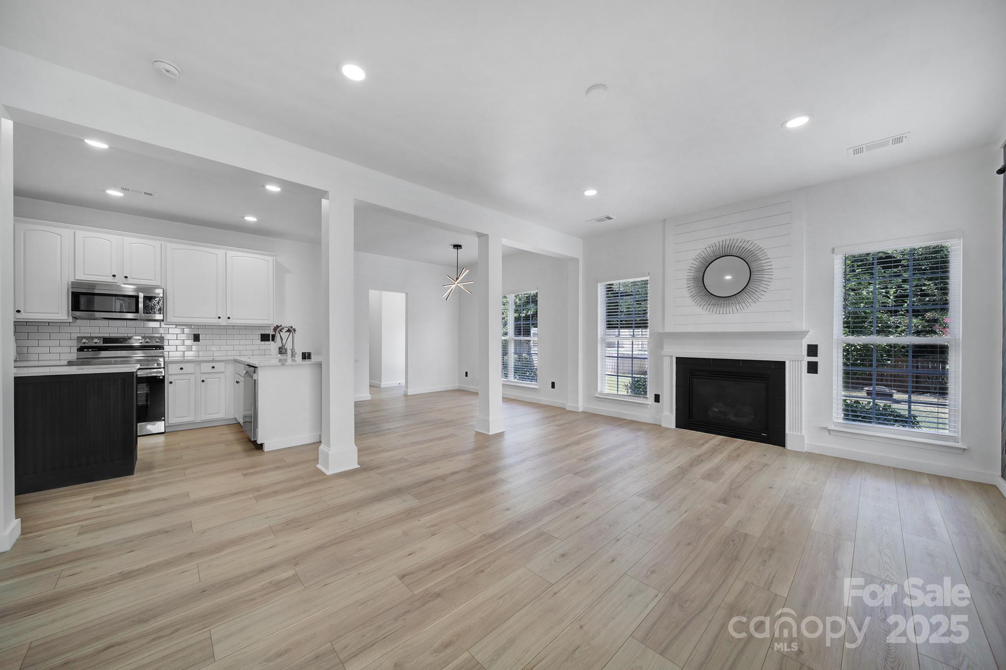 13425 Meadowmere Road Huntersville, NC 28078 - Photo 9 of 41 a view of kitchen with kitchen island wooden floor and fireplace