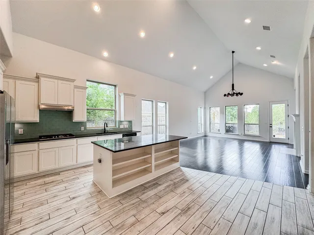 a kitchen with stainless steel appliances granite countertop a stove and a wooden floors