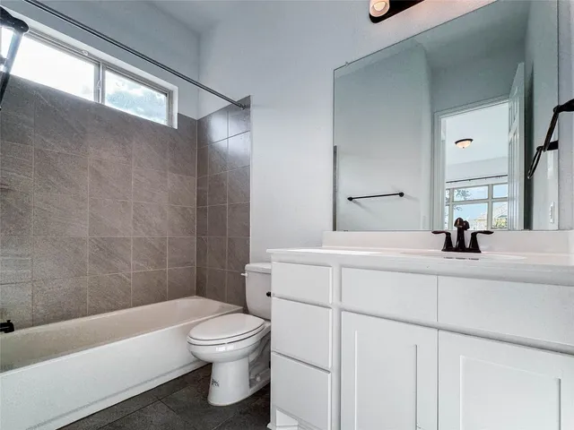 a bathroom with a bathtub shower sink vanity and toilet