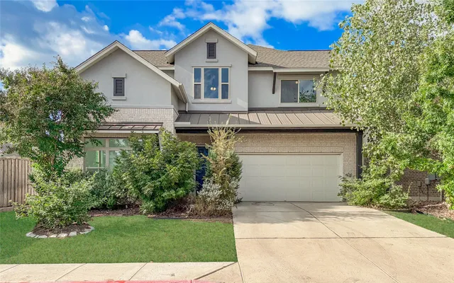 a view of backyard of house with large windows and trees