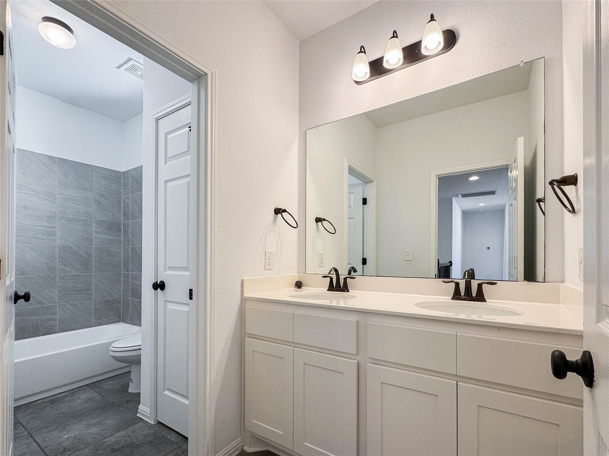 3810 Brushy Creek Road, Unit 73 Cedar Park, TX 78613 - Photo 28 of 42 a bathroom with a double vanity sink toilet mirror and bathtub