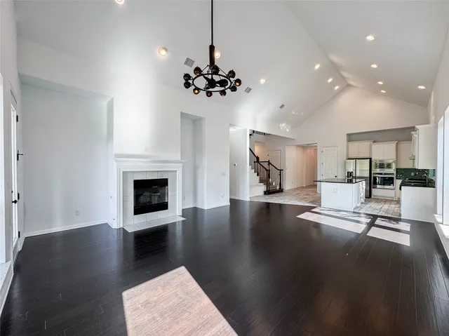 a view of a work space with a fireplace wooden floor and a kitchen view