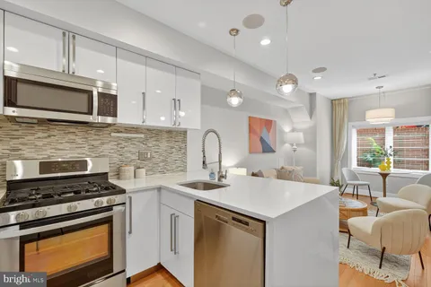 a kitchen with stainless steel appliances granite countertop a stove a sink and a microwave