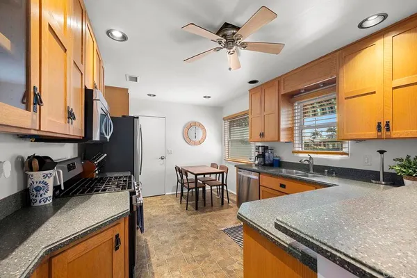 a kitchen with stainless steel appliances granite countertop sink stove top oven and cabinets