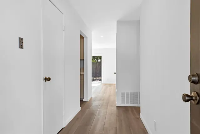 a view of a hallway with wooden floor