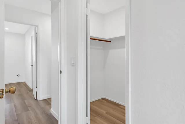 a view of a hallway with wooden floor