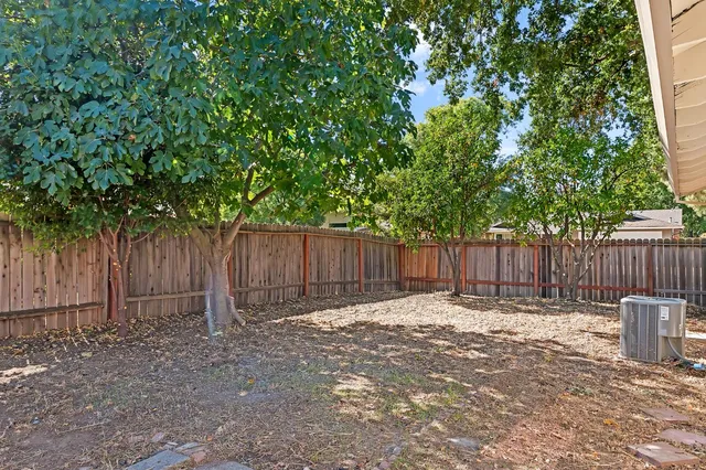 a view of a backyard with wooden fence and a fence