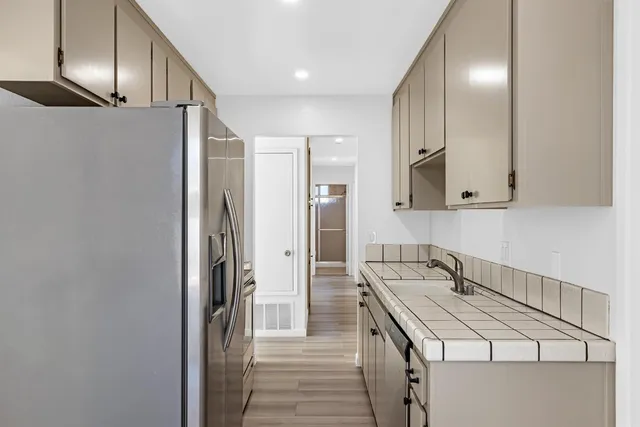 a kitchen with stainless steel appliances granite countertop a refrigerator and a sink