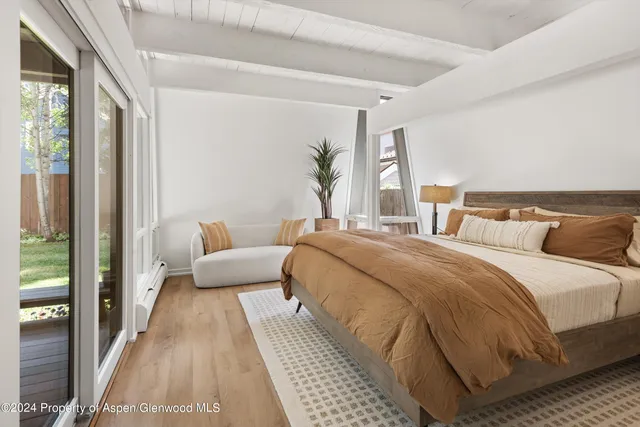 a bedroom with a bed lamp and a large window