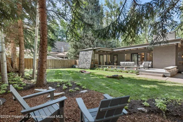 a front view of a house with garden and a patio